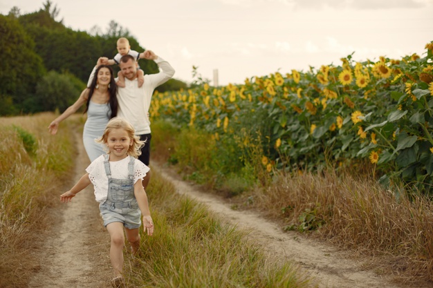 photo-happy-family-parents-daughter-family-together-sunflower-field-man-white-shirt_1157-39572
